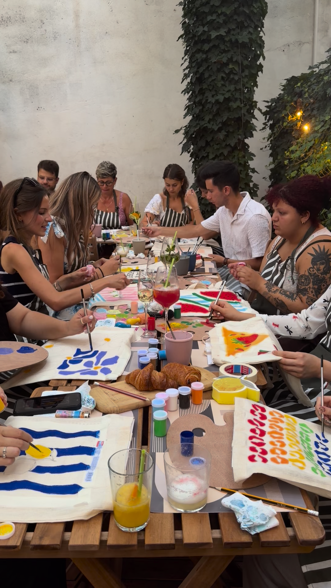 Group tote bag painting session — everyone working on their own design